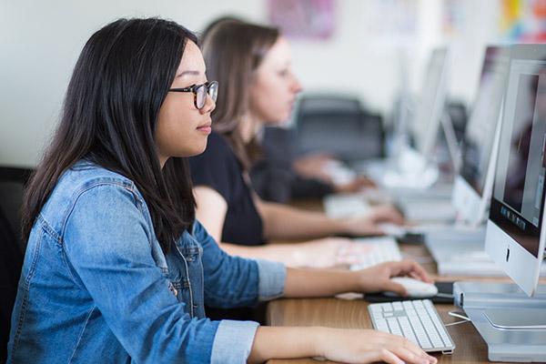 Profile close up of design students sitting at their computer workstations